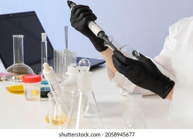 Pharmacology Concept. Drug Testing. Hands Of A Lab Assistant With Flask And Pipette. Laboratory Employee At Work. Hands Of Chemist, Medical Laboratory Assistant, Scientist. Laboratory Medical Tests