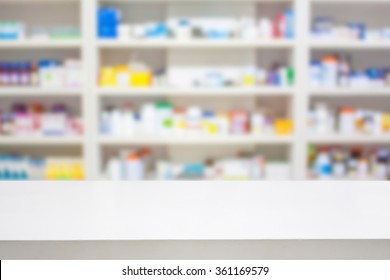 Pharmacy Counter With Blur Shelves Of Drug In The Drugstore Background