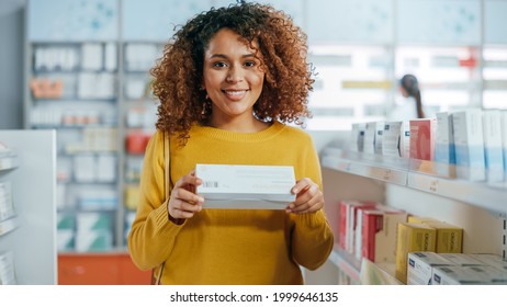 Pharmacy Drugstore: Portrait Of A Beautiful Black Young Woman Holding Right  Medicine Package And Smiles Looking At Camera. Health Care, Beauty Cosmetics Products With Modern Design