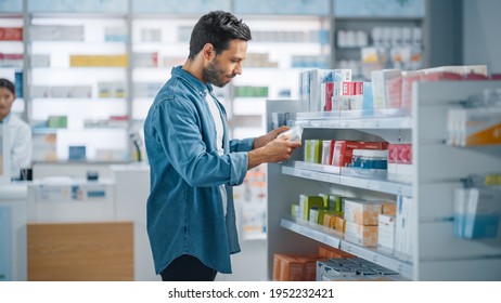 Pharmacy Drugstore: Portrait of Handsome Young Latin Man Searching to Purchase Best Medicine, Chooses between Two Packages of Drugs, Vitamins. Shelves full of Health Care, Wellness, Sport Supplements - Shutterstock ID 1952232421