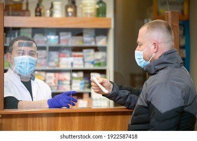 Pharmacy During Covid-19. Shopper In Drugstore. People In Protective Medical Masks Buys Medicine. Pharmacy, Pharmacist. Covid And Retail