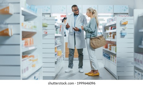 Pharmacy: Professional Black Pharmacist Helping Caucasian Senior Female Customer with Medicine Recommendation, Advice, Talking. Cusotmer Support in Drugstore Full of Drugs, Pills, Health Care Products