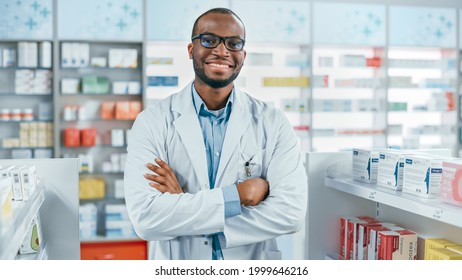 Pharmacy: Professional Confident Black Pharmacist Wearing Lab Coat and Glasses, Crosses Arms and Looks at Camera Smiling Charmingly. Druggist in Drugstore Store with Shelves Health Care Products