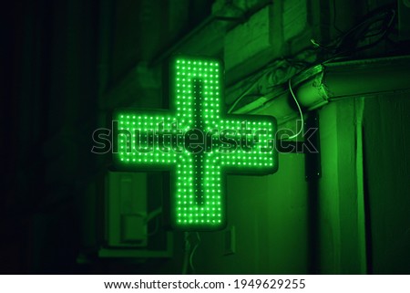 Pharmacy sign board in cross shape with backlit in night
