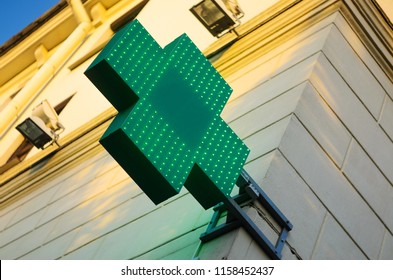 Pharmacy Sign with Green LEDs on the Facade Wall During Sweet Sunset Time
