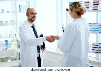 pharmacy staff greeting each other with a handshake.