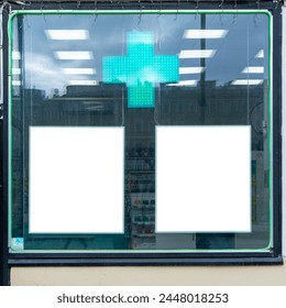 Pharmacy storefront with glowing green cross and two blank advertisement spaces. Reflection of urban environment on pharmacy window reveals city life outside. - Powered by Shutterstock