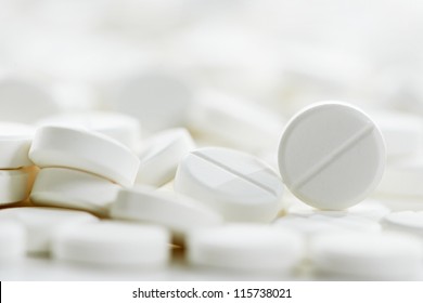 Pharmacy theme, Heap of white round medicine tablet antibiotic pills. Shallow DOF