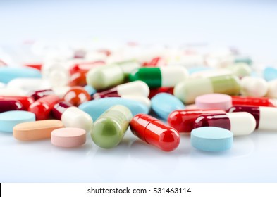 Pharmacy theme. Multicolored Isolated Pills and Capsules on the White Surface. Closeup.