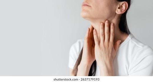 Pharyngitis, sore throat, thyroid problems, banner view. Sick woman touching neck and checking lymph nodes while feeling unwell. Advertising studio shot with copy space on white backgrounds