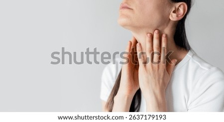 Pharyngitis, sore throat, thyroid problems, banner view. Sick woman touching neck and checking lymph nodes while feeling unwell. Advertising studio shot with copy space on white backgrounds