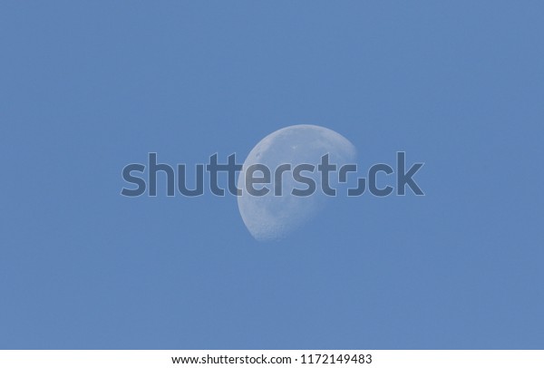 A phase\
of the moon against a blue sky in the\
UK.