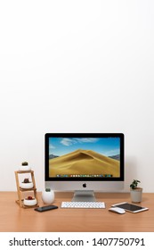 PHATTHALUNG, THAILAND - APRIL 21, 2019: IMac Computer, Keyboard, Magic Mouse, IPhone X, IPad Mini, Plant Vase And Cactus Pots On Wooden Table, Created By Apple Inc.