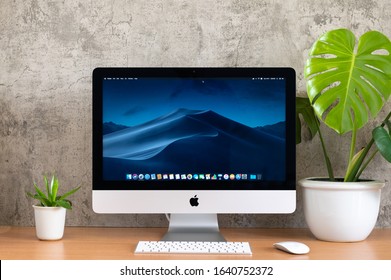 PHATTHALUNG, THAILAND - JANUARY 12, 2020: iMac computer, keyboard, magic mouse, monstera plant pot on wooden table, created by Apple Inc.
