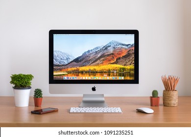 PHATTHALUNG, THAILAND - MARCH 24, 2018: iMac monitor computers, iPhone, keyboard, magic mouse  and plants vase on white desk, created by Apple Inc.