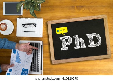 PhD Doctor of Philosophy Degree Education Graduation Businessman working at office desk and using computer and objects, coffee, top view,