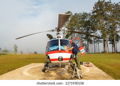 PHETCHABOON, THAILAND - DEC.25, 2018 : Airbus Eurocopter AS350 helicopter at Tung Salang Luang National Park park on helipad with a flight crew pre flight external check