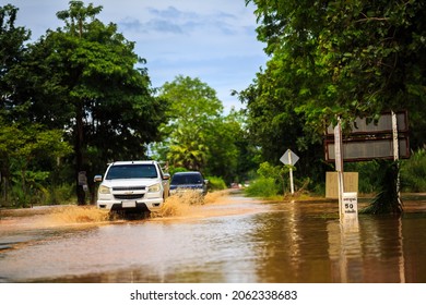 PHETCHABUN, THAILAND - October 22, 2021- Cars driving on a flooded road during a flood caused by heavy rain in Nongphai District at Phetchabun Province, Thailand