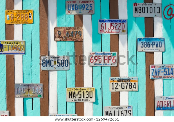 Phetchaburi, Thailand - December 25, 2018:\
Collection of old vintage or retro American car license plates\
collage on old color pastel painted wooden wall background for\
outdoor building\
decoration.