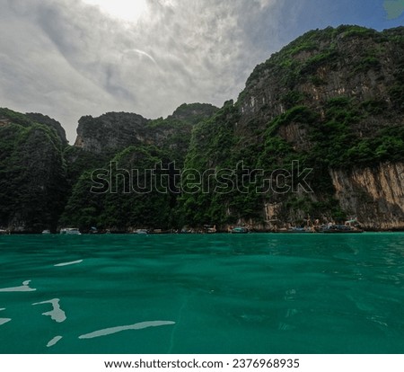 Phi Phi island off the coast of phuket thailand. Phi phi island is famous for turquoise clear blue waters teaming with Corel reef fish white soft sand and lush green trees.