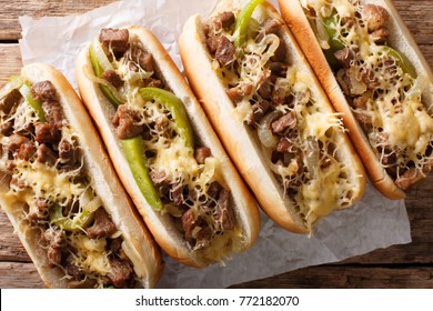 Philadelphia cheesesteak sandwich close-up on paper on the table. Horizontal top view from above