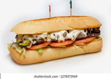 Philadelphia Cheesesteak Sandwich On A Sub Bun With Tomato And Lettuce.  Tooth Picks.  Isolated On White Background.