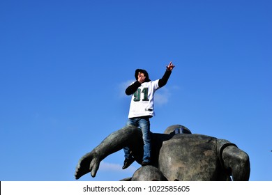 PHILADELPHIA, PA - February 8, 2018: Overjoyed Eagles Fan Celebrates Super Bowl LII Championship Atop Bronze Statue During Victory Parade