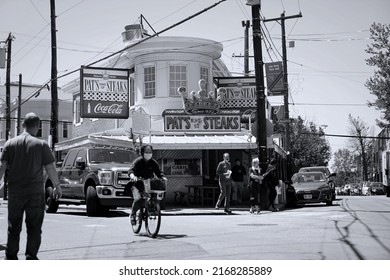 Philadelphia, PA - May 2022: People Are Going About Their Day In Front Of Pat's King Of Steaks In Black And White