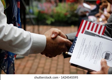 Philadelphia, PA / USA - June 14, 2019: A New United States Citizen Receives A Warm Handshake And Congratulations During A Special Naturalization Ceremony On Flag Day At The Historic Betsy Ross House.