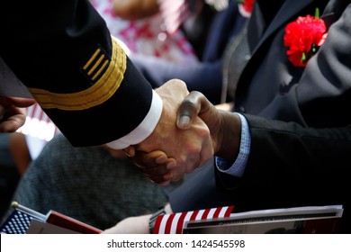 Philadelphia, PA / USA - June 14, 2019: A New United States Citizen Receives A Warm Handshake And Congratulations During A Special Naturalization Ceremony On Flag Day At The Historic Betsy Ross House.