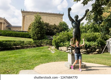 PHILADELPHIA, PENNSYLVANIA - Aug 29, 2015: Tourist posing with the Rocky statue, a movie memorial close to the 72 Rocky steps before the entrance of the Philadelphia Museum of Art