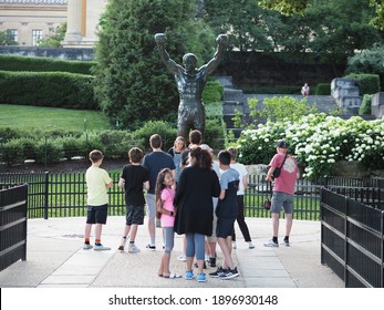 Philadelphia, USA - June 11, 2019: Several tourists posing and taking pictures next to the Rocky statue in Philadelphia.