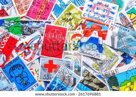 Philately.Postage stamps.Collection of stamps and magnifying glass.A collection of world stamps in a pile.Postage stamps from different countries and times