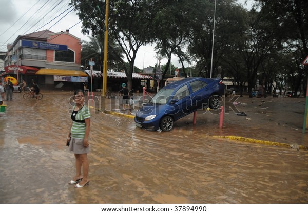 PHILIPPINES – CIRCA SEPT 2009:A car is left\
useless at Marikina street circa Sept 2009 in the Philippines.\
Typhoon Ondoy left hundreds of thousand families displaced and\
killed hundreds of\
people