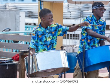 PHILIPSBURG, ST. MARTIN/DUTCH WEST INDIES - JANUARY 31, 2019: Photo Of A Smiling Young Steel Pan Player With Her  Playing Upbeat Music For Cruise Ship Visitors In The Harbor Area. 