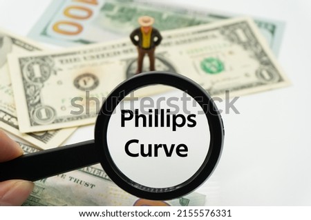 Phillips Curve.Magnifying glass showing the words.Background of banknotes and coins.basic concepts of finance.Business theme.Financial terms.