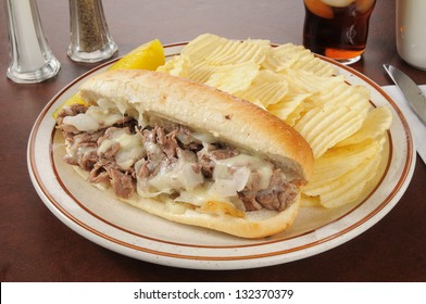 A Philly cheese steak sandwich with french fries and cola