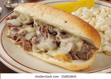 A Philly cheese steak sandwich with macaroni salad