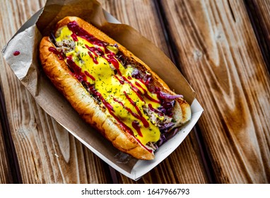 Philly cheese steak sandwich with meat, vegetables, cheese and sause in box on wooden table. street food - Shutterstock ID 1647966793