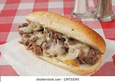 A Philly cheese steak sandwich on a picnic table