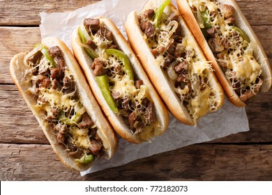 Philly cheese steak sandwich served on parchment paper close-up on the table. Horizontal top view from above