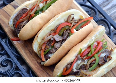 Philly Cheese Steak Sandwiches: Three Sandwiches Hoagie Buns Stuffed With Rib Eye Steak Strips, Grilled Bell Peppers And Onions With Provolone Cheese Slices.