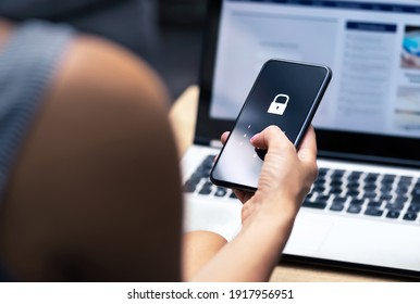 Phishing, mobile phone hacker or cyber scam concept. Password and login pass code in smartphone. Online security threat and fraud. Female scammer with cellphone and laptop. Bank account security. - Shutterstock ID 1917956951