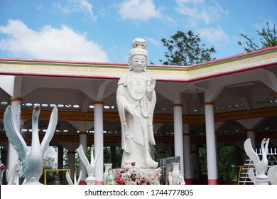 PHITSANULOK, THAILAND – MAY 30, 2020: A statue of the white Lady Buddha or Guan Im standing to make by jade under sun light on noon at Wat Ratkisihirunyaram temple in Phitsanulok province of Thailand.