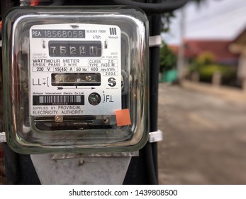 Phitsanulok, Thailand - May 4, 2019:Electric meter hung at the pole Background with houses - Shutterstock ID 1439808500