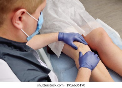 a phlebologist or vascular surgeon examines the varicose veins of the lower extremities of a patient in a modern dermatological clinic. Phlebology.