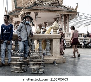 PHN, CAMBODIA - Apr 13, 2022: A street of small birds kept in cages near shrines for a merit release in Cambodia