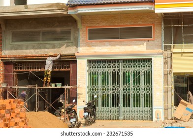 PHNOM PENH, CAMBODIA - FEBRUARY 27, 2014: A Brick Layer Puts The Finishing Touches On Building Renovation In This Busy And Economically Growing Asian Capital.