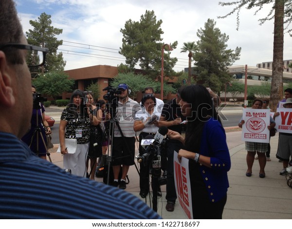 Phoenix, Ariz. / US - August 19, 2013: Supporters of\
federal immigration raids detainees rally outside Immigration and\
Customs Enforcement, hoping to prevent deportations and reunite\
families. 1332