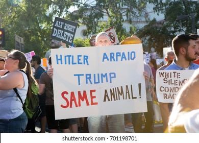 Phoenix, Arizona - August 22, 2017: Anti-Trump protester demonstrates outside of the Phoenix Convention Center while Trump delivers a speech, holding a Hitler, Arpaio and Trump are the same sign